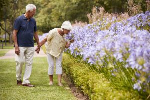 Ginger Cove Memory Care Couple walking smelling flowers