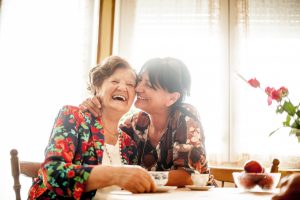 Ginger Cove Memory Care Two women laughing at a table